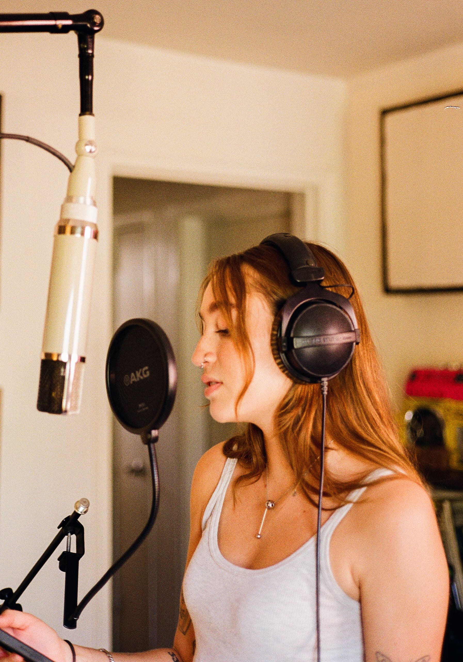Emma Grace Burton recording vocals into a studio microphone